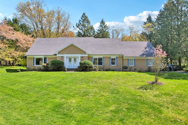 ranch-style home featuring french doors and a front yard