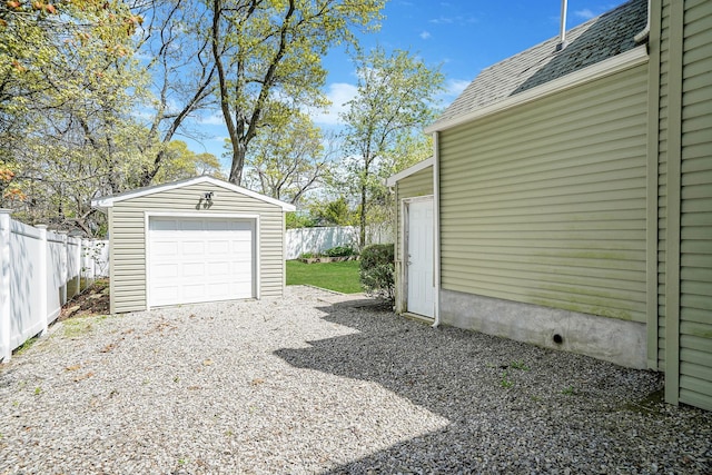 detached garage with fence and driveway