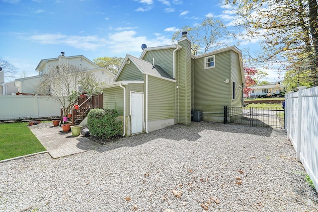 rear view of house with a fenced backyard, a patio, a chimney, and cooling unit