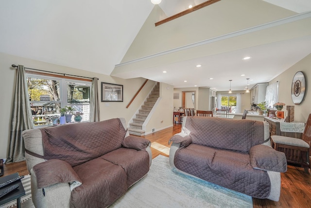 living room featuring recessed lighting, wood finished floors, vaulted ceiling, and stairway