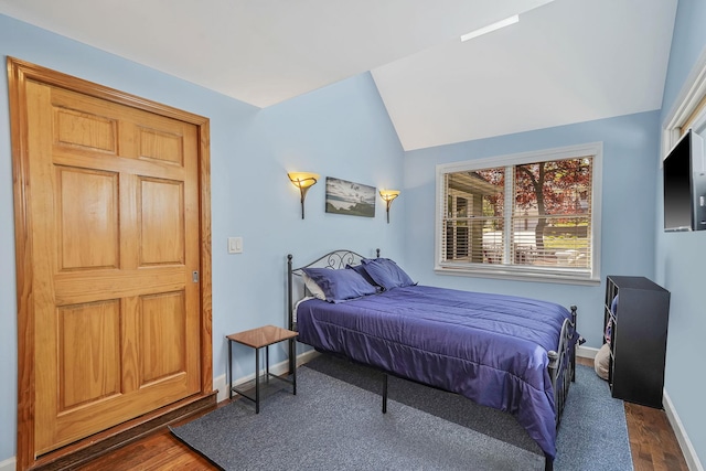 bedroom featuring baseboards, vaulted ceiling, and dark wood-style floors