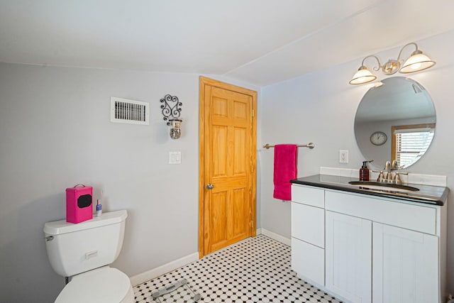 bathroom featuring vanity, toilet, baseboards, lofted ceiling, and visible vents