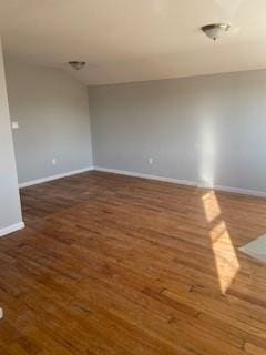 unfurnished room with baseboards and wood finished floors