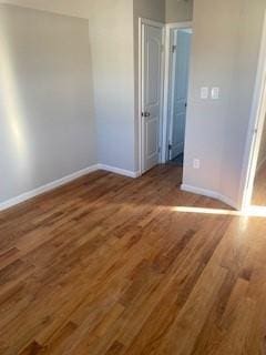 unfurnished bedroom with baseboards and wood finished floors
