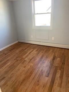 empty room with baseboards and wood finished floors