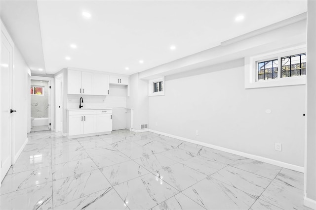 unfurnished living room with baseboards, recessed lighting, and marble finish floor