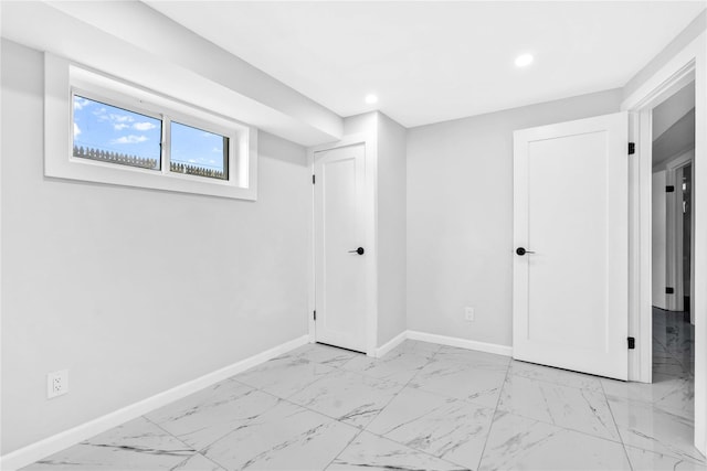 basement with baseboards, recessed lighting, and marble finish floor