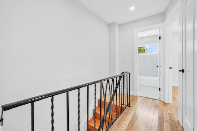 hallway with recessed lighting, baseboards, an upstairs landing, and light wood finished floors