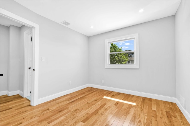 empty room with baseboards, recessed lighting, light wood finished floors, and visible vents