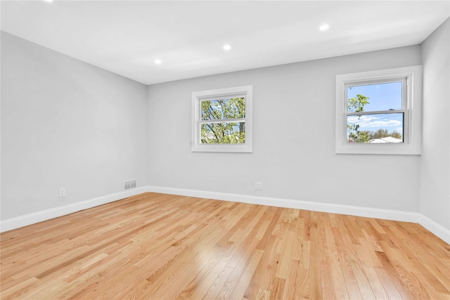 spare room featuring baseboards, recessed lighting, wood finished floors, and visible vents