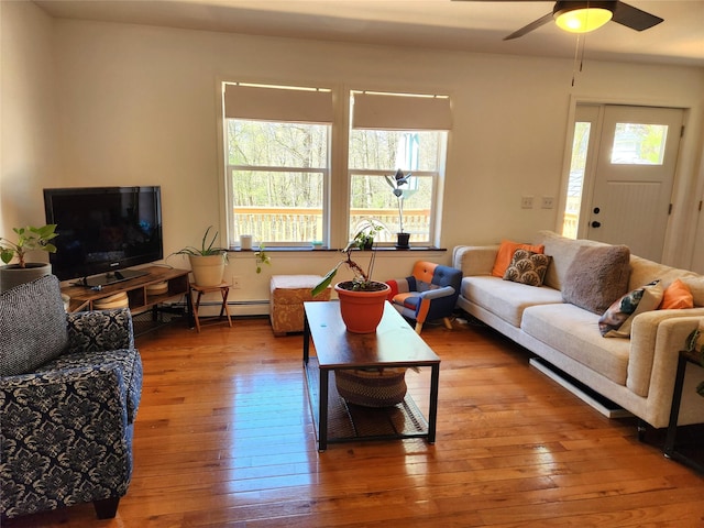 living room with wood-type flooring, ceiling fan, and a baseboard heating unit