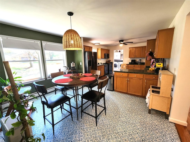 dining room featuring washer / clothes dryer, a ceiling fan, and baseboards