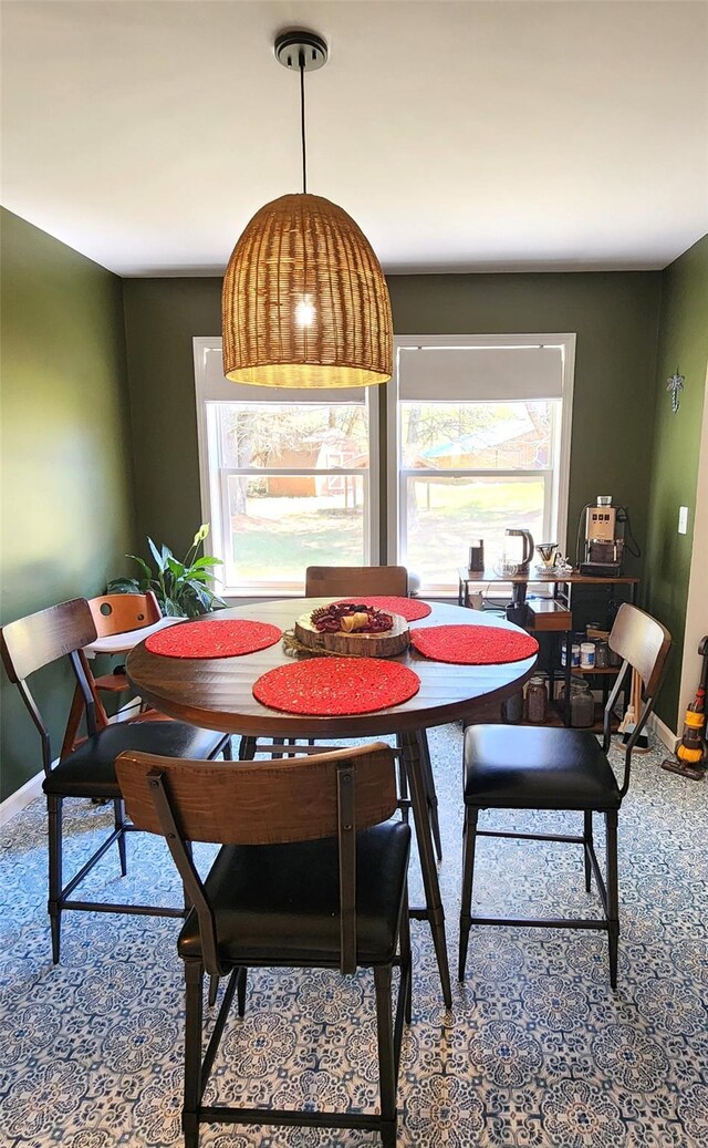 carpeted dining room with baseboards and a healthy amount of sunlight