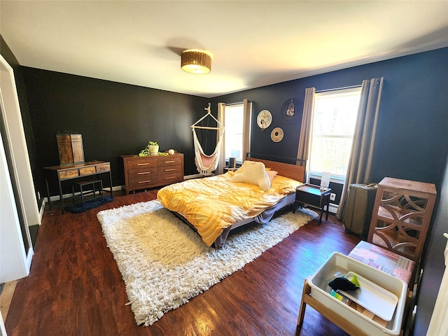 bedroom with wood finished floors and multiple windows