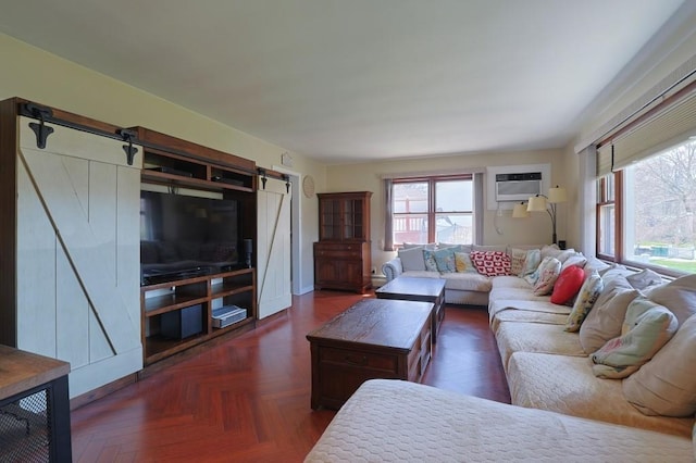 living room featuring a barn door and a wall unit AC