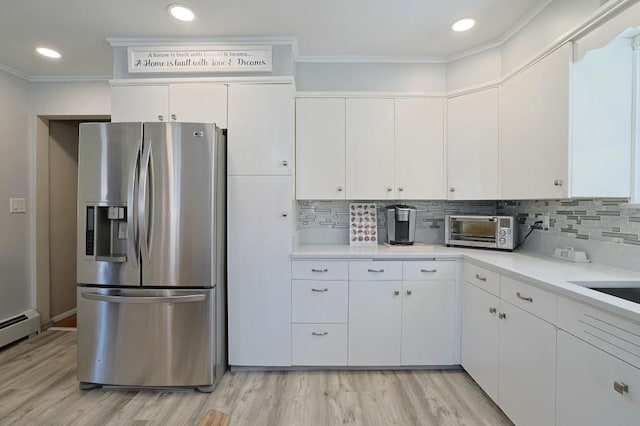 kitchen with crown molding, a toaster, stainless steel fridge with ice dispenser, light countertops, and light wood finished floors