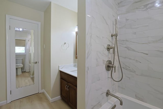 full bathroom featuring vanity, shower / bathtub combination, wood finished floors, toilet, and baseboards