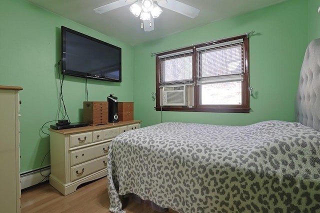 bedroom with light wood-type flooring, a baseboard radiator, a ceiling fan, and cooling unit