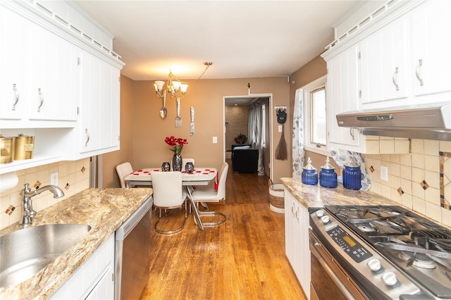 102 Capt Shankey Dr, Garnerville, NY 10923 - kitchen featuring stainless steel appliances, under cabinet range hood, a sink, a chandelier, and white cabinetry