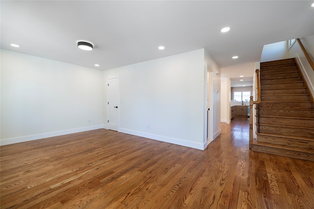 unfurnished room with stairs, recessed lighting, baseboards, and wood finished floors