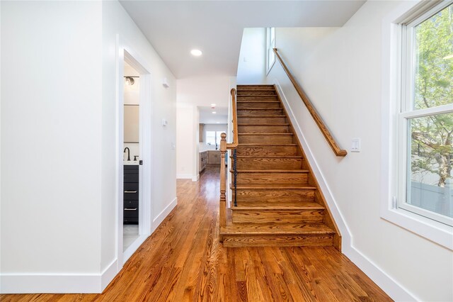 stairway featuring baseboards, recessed lighting, and wood finished floors