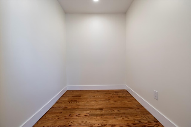 unfurnished room with baseboards and wood finished floors