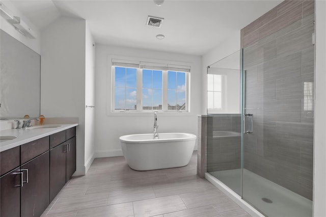 full bath featuring baseboards, a sink, a stall shower, and a healthy amount of sunlight