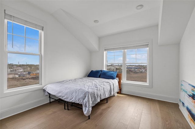 bedroom featuring baseboards, vaulted ceiling, and wood finished floors