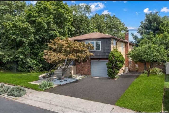 view of front of home with a chimney, a front yard, stairway, aphalt driveway, and an attached garage