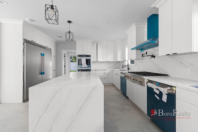 kitchen featuring white cabinetry, appliances with stainless steel finishes, and wall chimney range hood