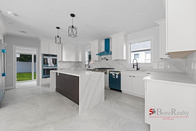 kitchen with a sink, wall chimney exhaust hood, stainless steel appliances, backsplash, and visible vents