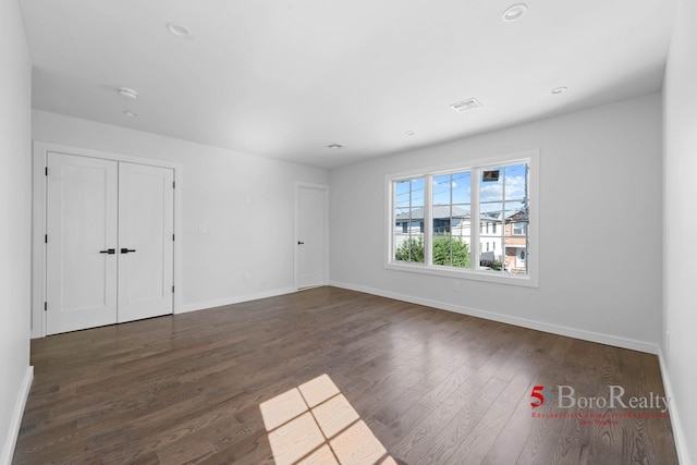 spare room with visible vents, recessed lighting, baseboards, and dark wood-type flooring