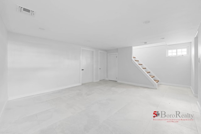 below grade area with baseboards, stairs, and visible vents