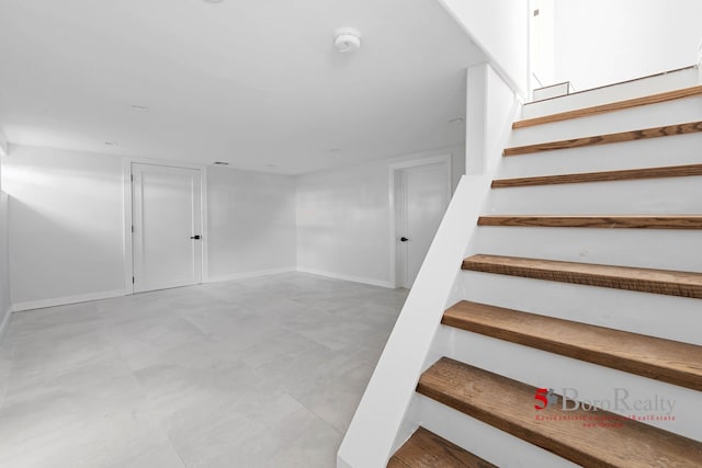 staircase with baseboards and tile patterned floors
