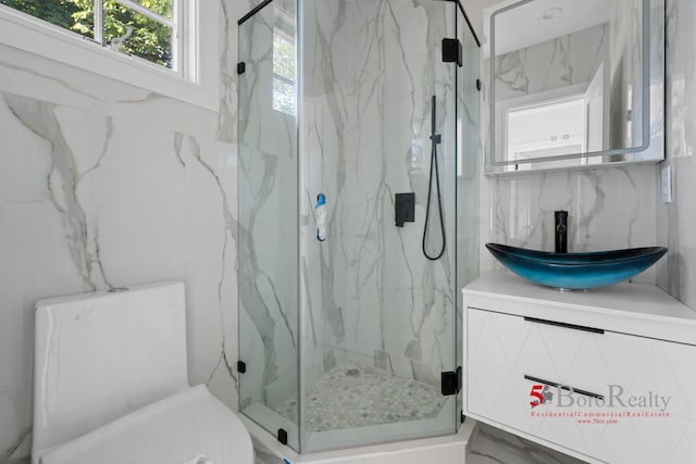 bathroom with vanity and a marble finish shower