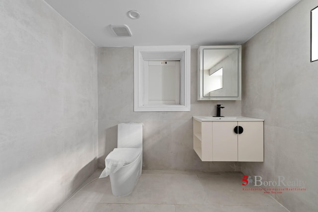 bathroom with tile patterned floors, visible vents, and vanity