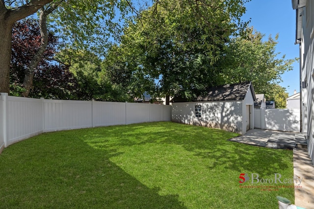 view of yard with an outdoor structure and a fenced backyard