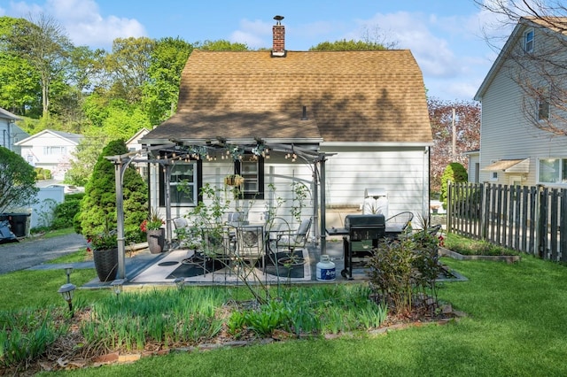 67 Summers St, Oyster Bay, NY 11771 - rear view of property featuring fence, a shingled roof, a chimney, a patio area, and a yard