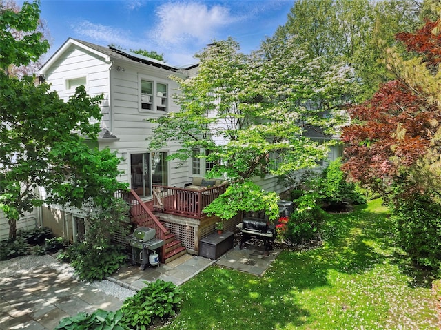 back of house with a deck, a lawn, a patio, and stairway