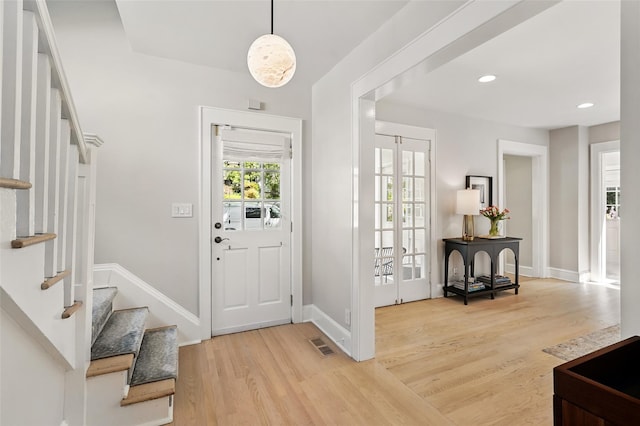foyer with wood finished floors, stairway, baseboards, and recessed lighting