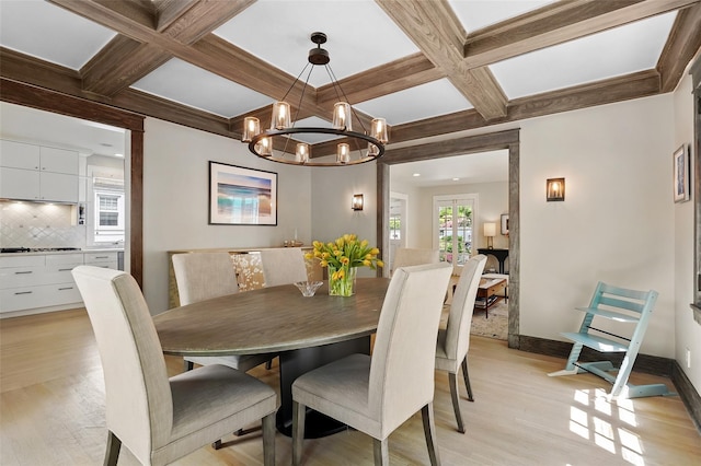 dining area featuring coffered ceiling, light wood-style floors, a chandelier, beam ceiling, and baseboards