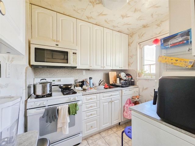 kitchen with light countertops, white appliances, and white cabinetry