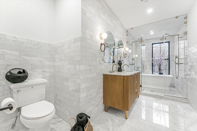 bathroom featuring tile walls, a freestanding tub, a stall shower, vanity, and toilet