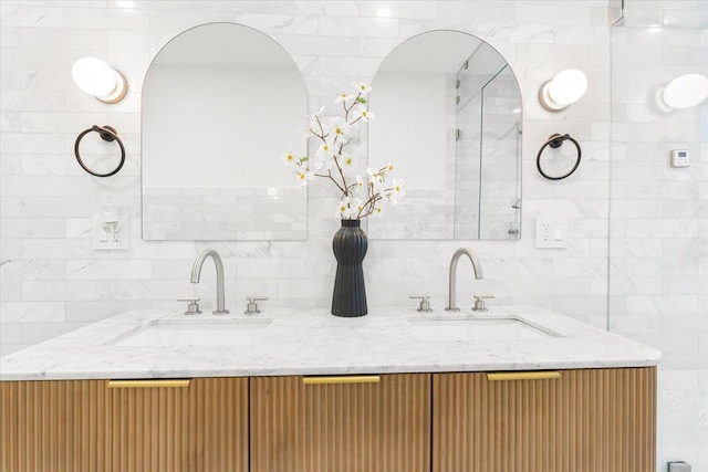 bathroom featuring double vanity, a sink, decorative backsplash, and tile walls