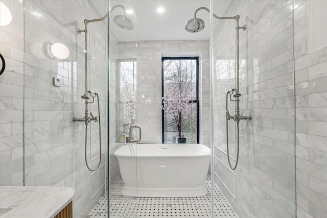 bathroom with a tile shower, vanity, tile patterned floors, a freestanding tub, and tile walls