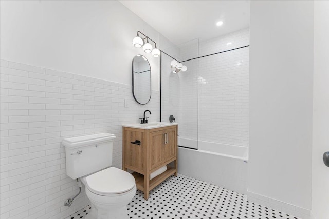 full bathroom with vanity, shower / washtub combination, toilet, and tile walls