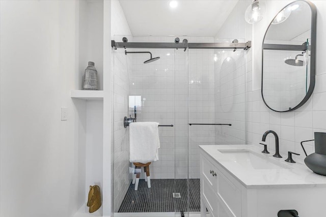 full bath with vanity, a shower stall, and tile walls