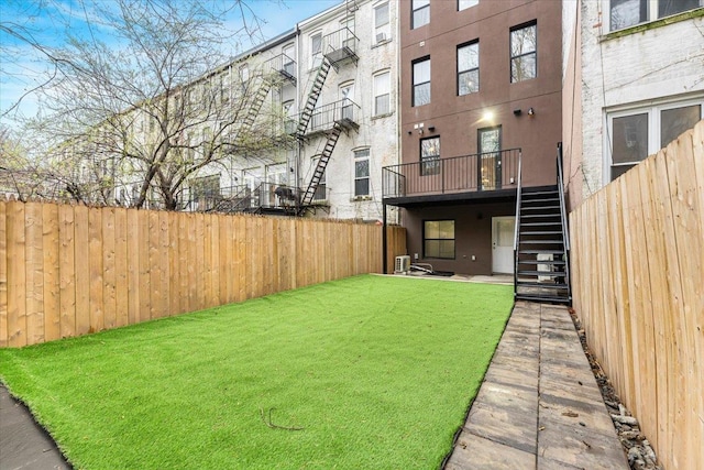 view of yard featuring fence and stairway