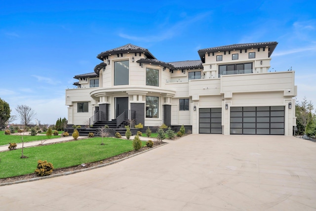 view of front of house with a garage, a tiled roof, driveway, and a front lawn