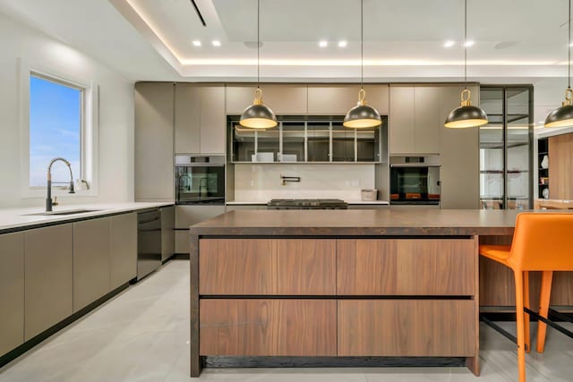 kitchen featuring dark countertops, a sink, gray cabinets, modern cabinets, and dishwashing machine